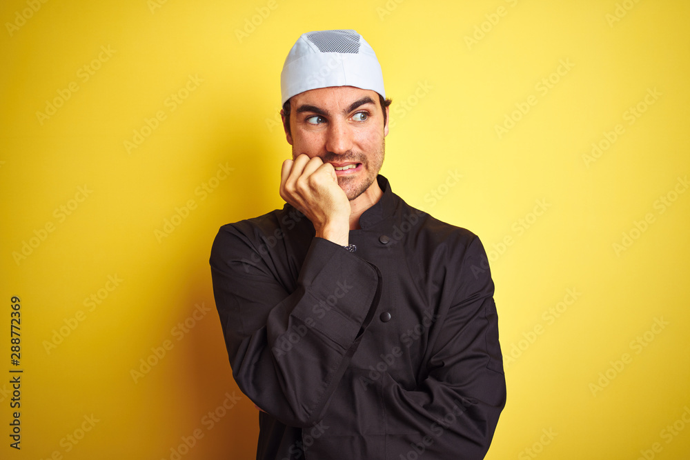 Young handsome chef man cooking wearing uniform and hat over isolated yellow background looking stressed and nervous with hands on mouth biting nails. Anxiety problem. Young handsome chef man cooking wearing uniform and hat over isolated yellow background looking stressed and nervous with hands on mouth biting nails. Anxiety problem.