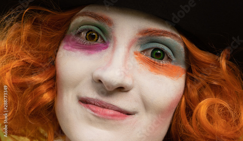 Portrait of a beautiful young woman with red hair, .different colored contact lenses and colorful make-up