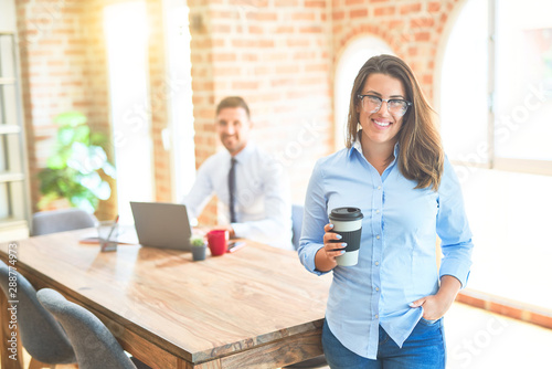 Young business team working at the office, head office woman standing smilig positive drinking a cup of coffee photo