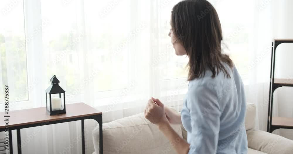 Woman moving into new house decorating plants and lamp on shelf Woman moving into new house decorating plants and lamp on shelf