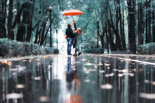 Εκτύπωση καμβά rain in the autumn park / young 25 years old couple man and woman walk under an