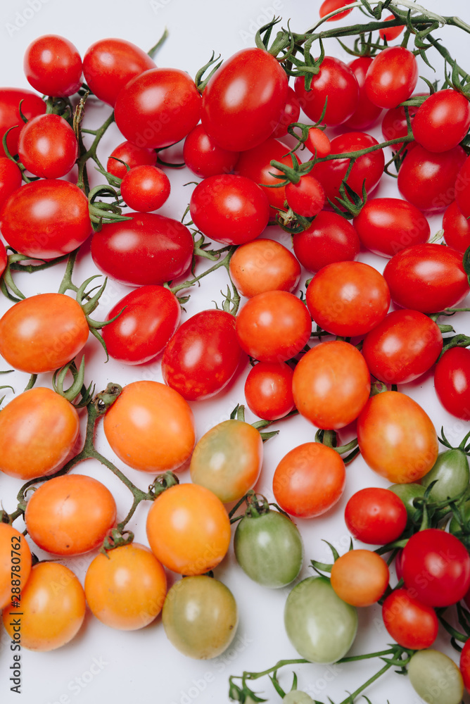 many yellow and red cherry tomatoes on a white background