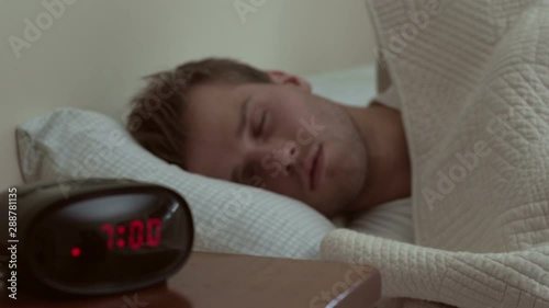 Man waking up to his alarm