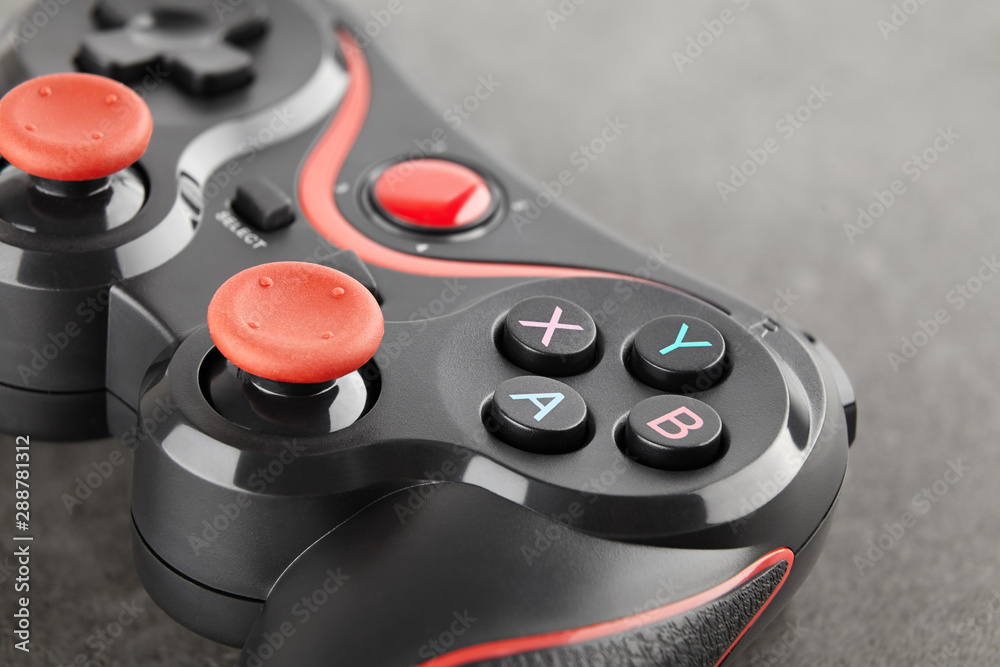 new wireless game controller close-up, black gamepad on a dark stone background
