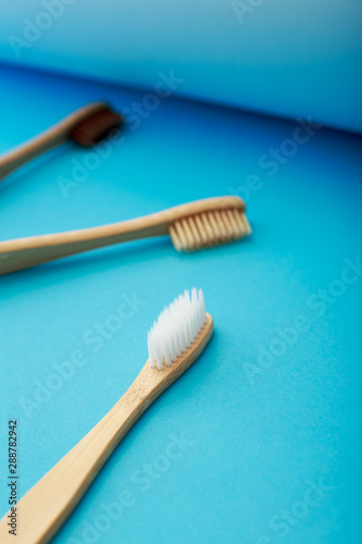 Dental care with eco friendly bamboo toothbrush on blue background. Zero waste and plastic free concept.