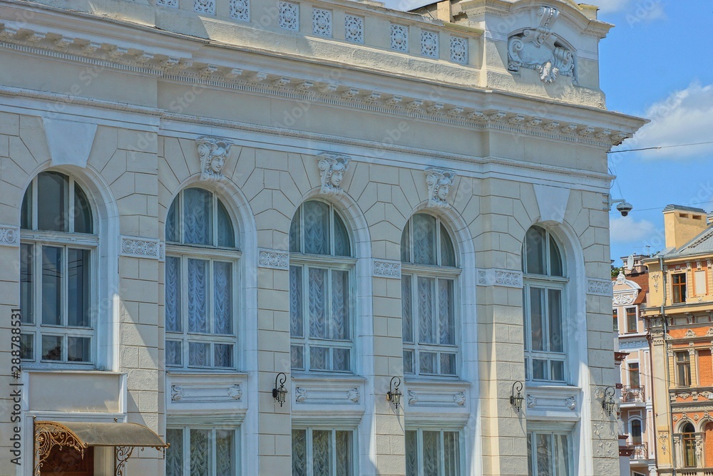 Fototapeta premium a row of old windows on the white wall of a large building
