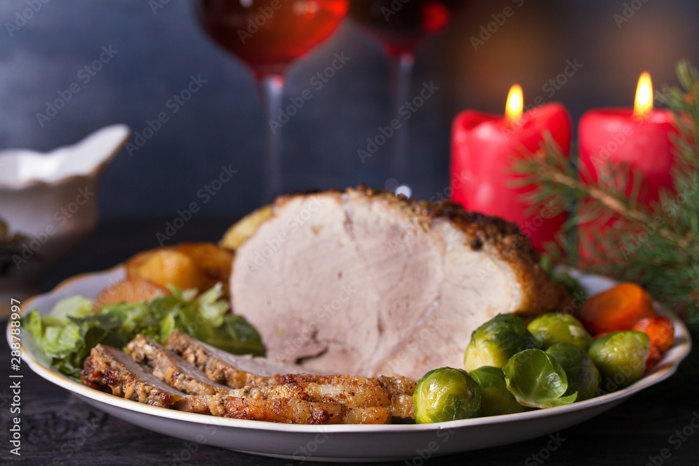 Baked ham with vegetables, two glasses of red wine. Christmas decorations. Dish for Christmas Eve Baked ham with vegetables, two glasses of red wine. Christmas decorations. Dish for Christmas Eve