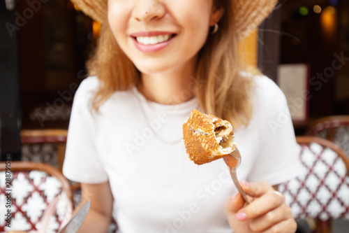 Fotografie Woman eating traditional french crepes galette - baked pancakes with cheese fill