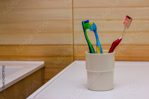 Toothbrushes stand on the sink on bathroom wall © habrovich