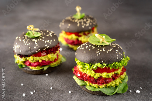 Vegan black burgers with beet patties on dark background