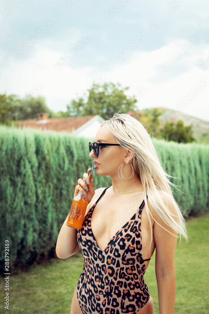 Girl drinking orange juice in garden.