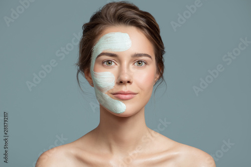 Portrait of beautiful woman with bluel cream mask on her face.