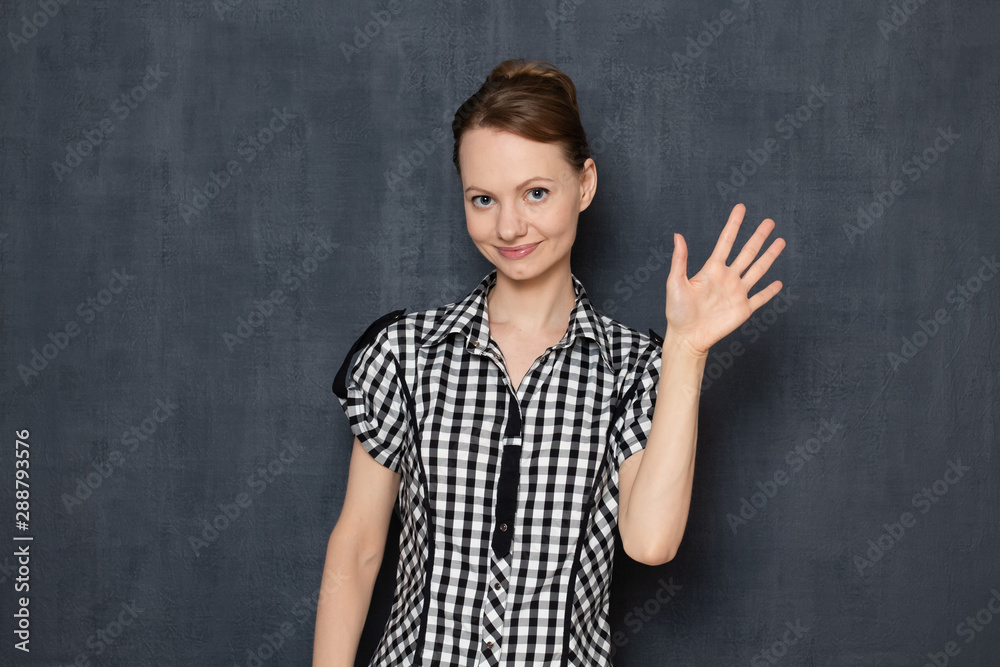 Portrait of happy girl raising her hand while greeting Portrait of happy girl raising her hand while greeting