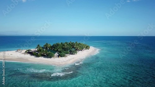 Idyllic Southsea island Fiji, Aerial push in rising above paradise turquoise ocean small island destination. photo