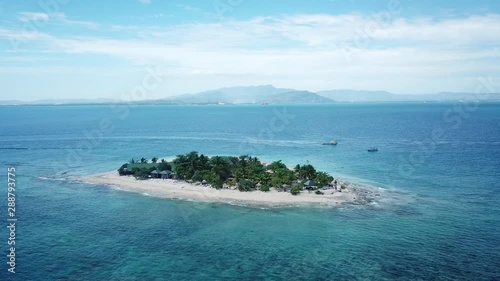 Southsea island Fiji, Aerial view above turquoise ocean reef water. Mountains in background. photo