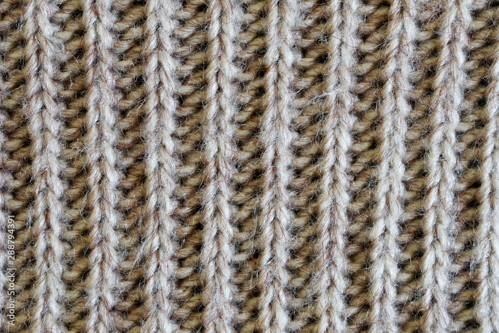 Knit woolen fabric with a vertical pattern. Warm clothes for winter and autumn cold. Texture for design or research Knit woolen fabric with a vertical pattern. Warm clothes for winter and autumn cold. Texture for design or research