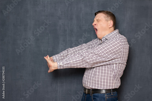 Portrait of man with arms stretched while yawning photo
