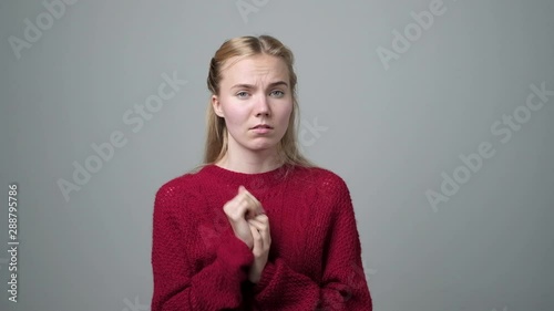 Very awkward situation concept. Shy quilty european woman, rubbing hands, feeling ashamed photo