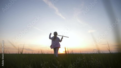 Wallpaper Mural Cute girl playing with toy wooden airplane in the field at sunset time. Silhouette of child playing wooden plane in the meadow. Relax time on holiday concept travel and freedom. Torontodigital.ca