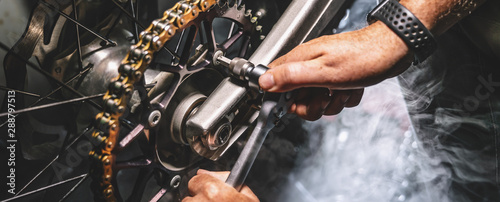 Mechanic working on motorcycle in garage. Repair service. photo