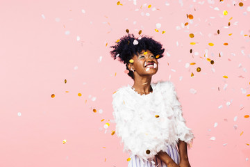 Smiling woman looking up at confetti falling