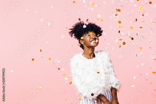 Smiling woman looking up at confetti falling