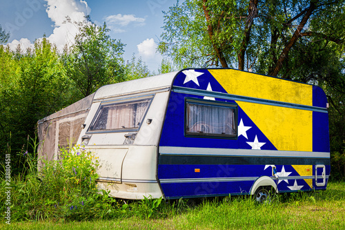 A car trailer, a motor home, painted in the national flag of  South African Republic stands parked in a mountainous. The concept of road transport, trade, export and import between countries.