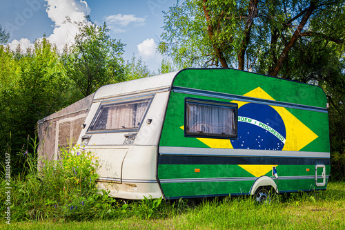 A car trailer, a motor home, painted in the national flag of  South African Republic stands parked in a mountainous. The concept of road transport, trade, export and import between countries.