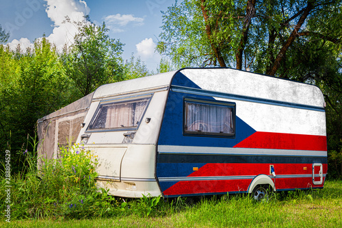 A car trailer, a motor home, painted in the national flag of  Czech stands parked in a mountainous. The concept of road transport, trade, export and import between countries.