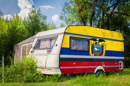 A car trailer, a motor home, painted in the national flag of  Ecuador stands parked in a mountainous. The concept of road transport, trade, export and import between countries.