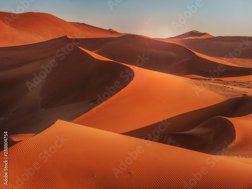 Sun rising over the red sand dunes of the Namib Desert, Namibia.