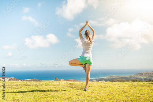 Female doing balancing exercise outdoors in a beautiful nature setting. 