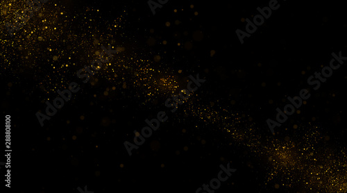 Golden glitter dust on black background