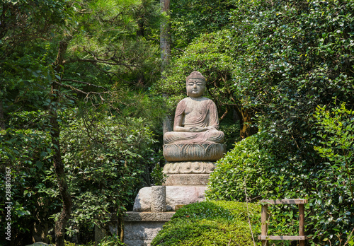 Statue of Buddha in the woods in Kyoto  Japan.