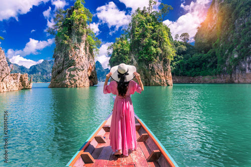 Asian woman posing on boat in Ratchaprapha dam Khao sok national park at suratthani,Thailand.
