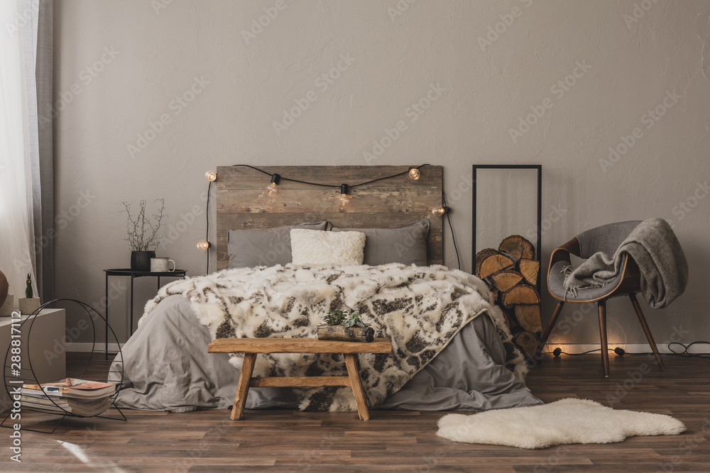 Copy space on empty grey wall of stylish bedroom interior with wooden accents and king size bed - obrazy, fototapety, plakaty 