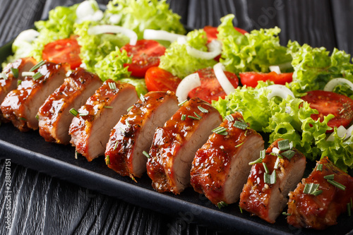 Bild auf Leinwand festive dish of baked pork tenderloin in honey-garlic sauce served with fresh vegetables close-up
