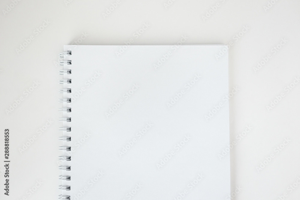 White empty paper notebook with spiral on white desk, top view. Mockup clean sheet, minimalism White empty paper notebook with spiral on white desk, top view. Mockup clean sheet, minimalism