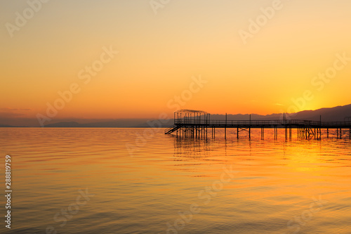 Beautiful sunset on a lake in the mountains. Kyrgyzstan  Issyk-Kul Lake. Bright sky  background in warm colors.