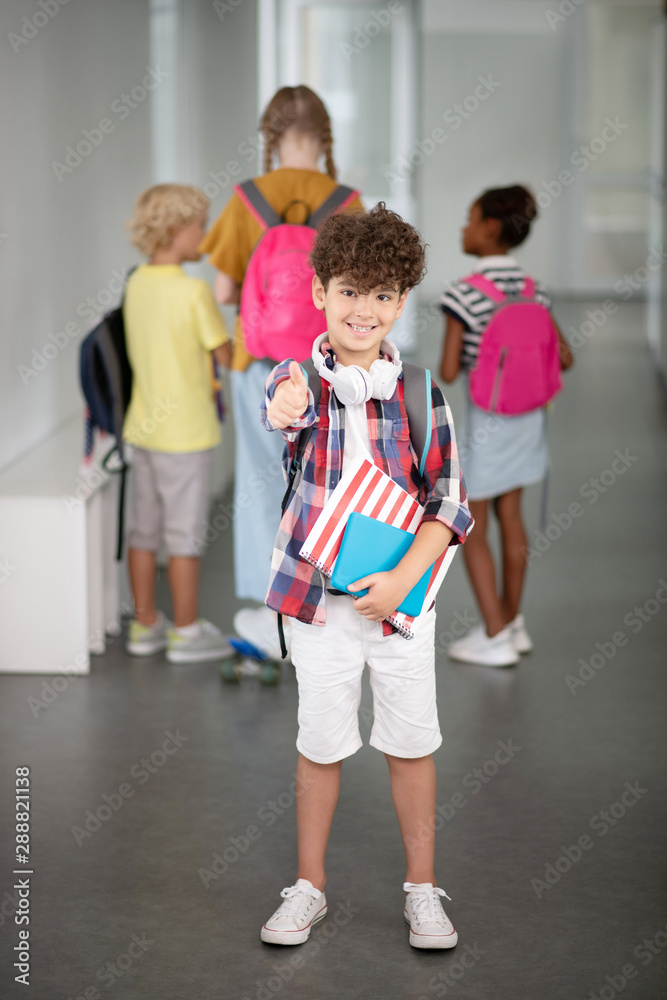 Curly dark-haired boy feeling positive at school Curly dark-haired boy feeling positive at school