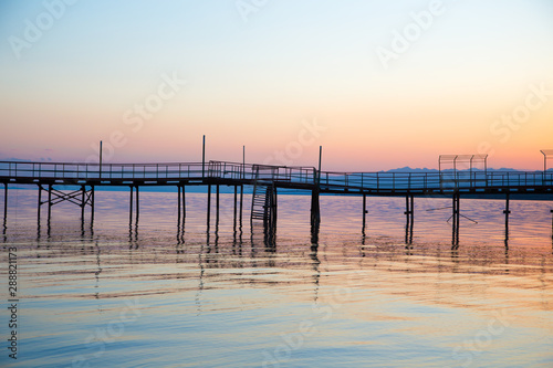 Beautiful sunset on a lake in the mountains. Kyrgyzstan  Issyk-Kul Lake. Bright sky  background in warm colors.