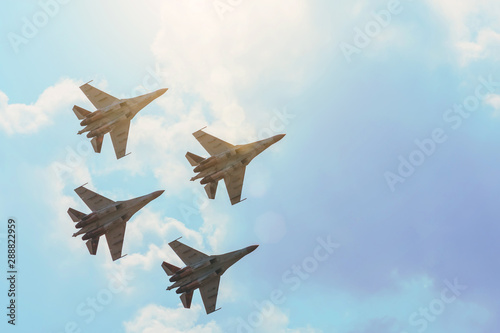 Group of four aircraft fighter jet airplane sun glow toned gradient clouds sky. photo