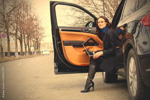 woman with a laptop sitting on the threshold of the vehicle