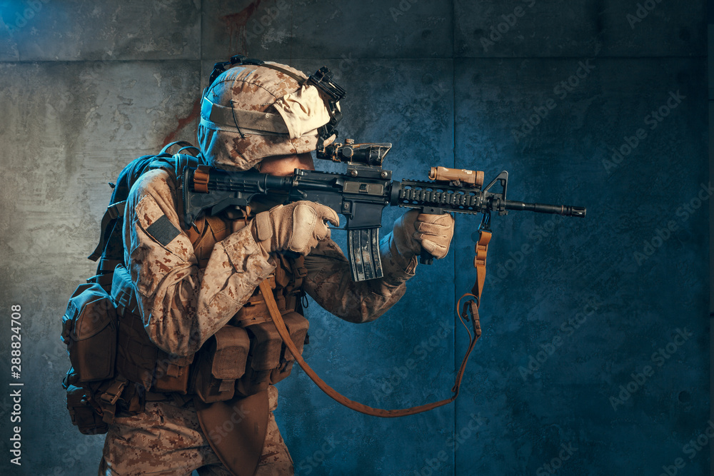 Fototapeta premium American private military contractor shooting a rifle. Studio shot