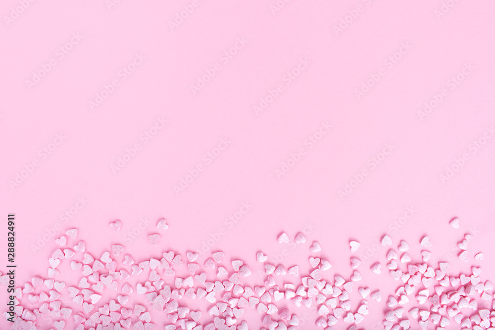 Pink background. Pink hearts on a pink background. Hearts sprinkles. Flat lay style. Top view. Place for design. Sweet background. Confetti. Pink background. Pink hearts on a pink background. Hearts sprinkles. Flat lay style. Top view. Place for design. Sweet background. Confetti.
