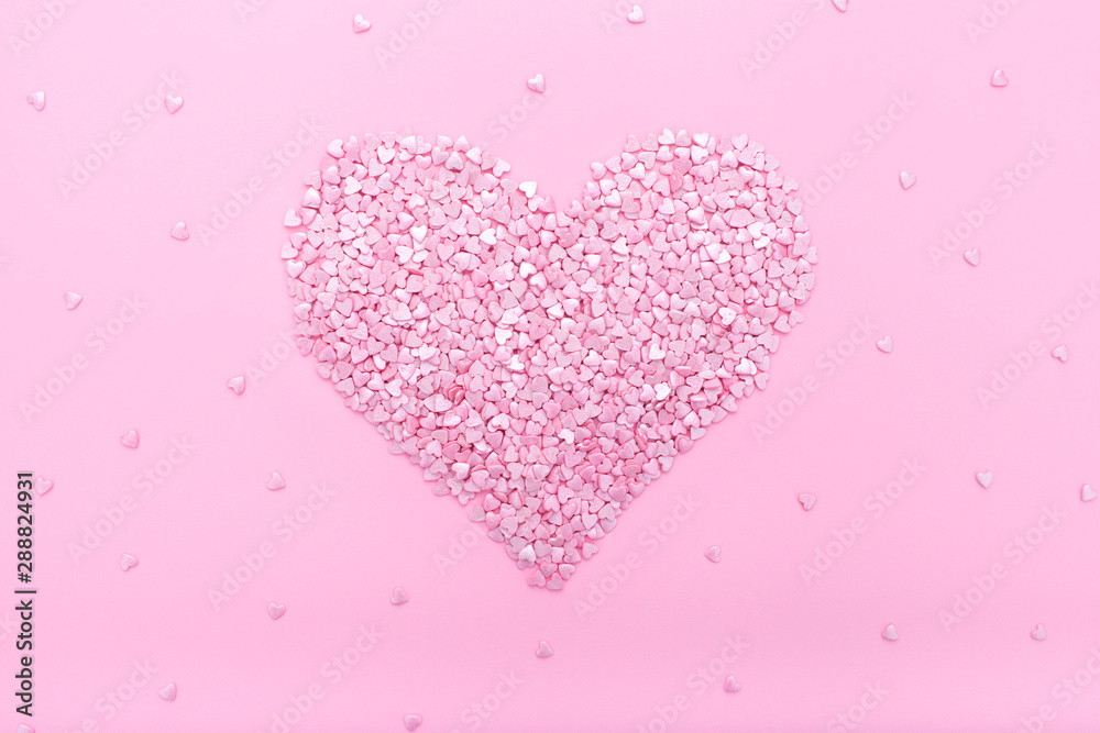 Pink background. Pink hearts on a pink background. Hearts sprinkles.  Flat lay style. Top view. Sweet background. Confetti.