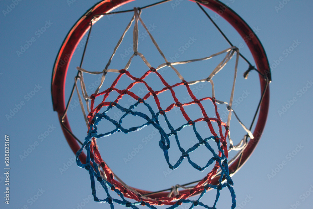 View of the basketball hoop with a net on a modern playground in the yard. Active lifestyle, basketball basket in the street. Equipped sports corners in the residential courtyard.