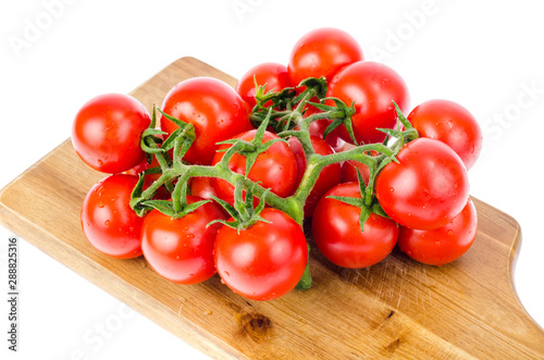 Wooden kitchen board with cherry tomatoes for cooking.