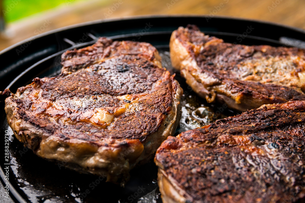 Grilled beef steak on the grill, close-up.