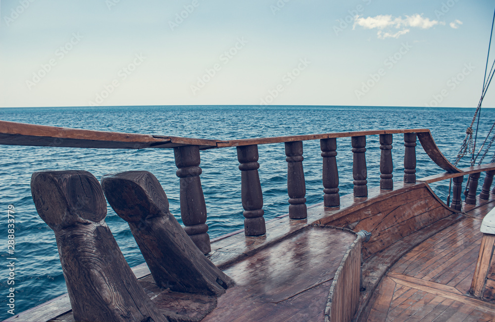 Sea/ocean view from the front of old wooden ship. The bow of a vintage ship.  The side of an ancient ship with bollards and pillars. Stock Photo